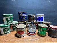 Group shot of all 14 assorted tobacco tins on tabletop