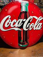 Full view of round Coca-Cola button sign front