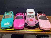 Front view of all four toy cars showing colors and styles