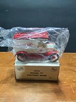 Model T delivery bank in plastic wrap atop original box