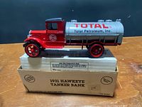 Die-cast 1931 Hawkeye tanker truck coin bank in Total Petroleum livery on top of original box