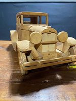 Front three-quarter view of wooden Model A showing radiator, headlamps, fenders, wheels, bumper, cab