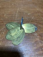 Four brass dog tags on ring, overall view