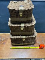 Stacked view of three wicker boxes, tape measure showing scale