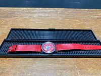 Watch laid in open black perforated plastic case