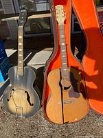 Both damaged guitars in cases, full view