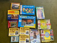 Group shot of all 12 puzzle boxes on green carpet