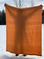Full view of peach wool blanket held upright showing overall colour and size