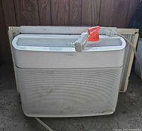 Front view of Frigidaire window air conditioner showing mesh grill and power cord