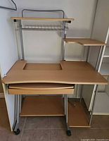 Front view showing overall structure, keyboard tray, drawer, shelves and casters