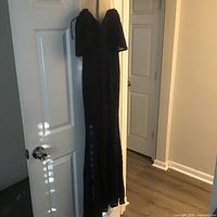 Full view of blue lace evening gown hanging on door