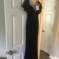 Full view of navy blue lace dress hanging on door