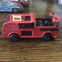 Red Metro Fire Dept Snorkel fire truck with additional cars in background