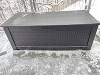 Closed Rubbermaid resin deck box on patio