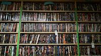Multiple wall shelves filled with DVDs