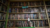 Wall of shelving densely packed with hundreds of thriller DVDs