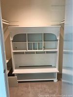Wooden desk hutch with multiple shelves and divider slots, white or cream color, minor wear and paint condition visible