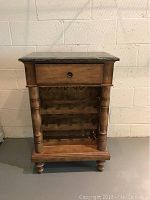 Front view of wooden wine rack cabinet with drawer and stone top