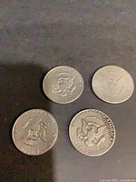 Four Kennedy half dollars, reverse side shown