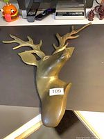 Front view of brass deer head wall mount showing antlers and overall form