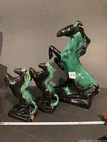 Front view of all three glazed ceramic horse figurines