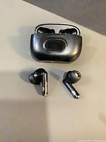 Earbuds and charging case displayed together