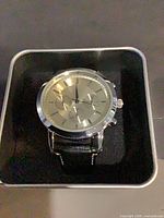 Watch in branded box, showing dial and strap