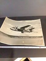 Full view of curled black-and-white photograph showing Navy aircraft