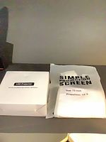 Projector box and folded 72" screen side by side