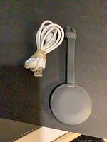 Chromecast dongle front with USB cable