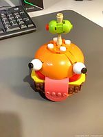 Front view of assembled LEGO Durrr Burger model showing eyes, tongue, bun and olive skewer