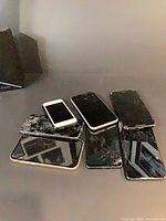 Six smartphones stacked showing cracked screens