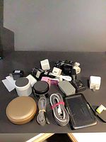 Lot overview showing chargers, cables, speaker, adapters