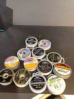 Front view of 13 spools stacked showing labels and finishes