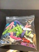 Full bag of assorted plastic clothespins and clips