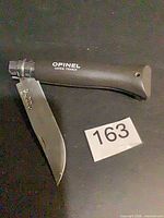 Knife open showing blade and handle with Opinel branding