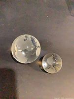 Medium and small crystal globe paperweights side by side