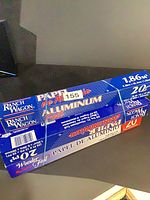 Three stacked unopened blue Ranch Wagon aluminum foil boxes, length and area markings visible