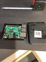 Raspberry Pi board in bottom half of case beside lid