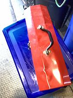 Exterior of red metal toolbox showing handle and latch