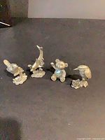 Front view of four pewter animal figurines