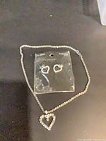 Necklace laid out with packaged heart earrings