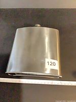 Front view of brushed stainless hip flask showing body and cap