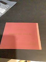 Front cover of pink souvenir booklet with gold lettering