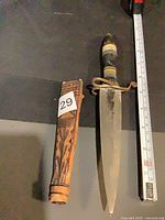 Dagger with sheath and measuring tape to show size