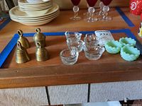overview showing brass bells, clear glass salt cellars, green glass salt cellars