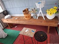 Full view of long wooden bench with legs