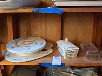 Cake pedestal, ceramic butter dish, glass butter dish on shelf