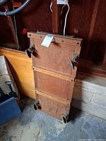 Rear view of wooden creeper showing casters and frame