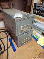 Two stacked gray Steelmaster metal file drawers on workbench